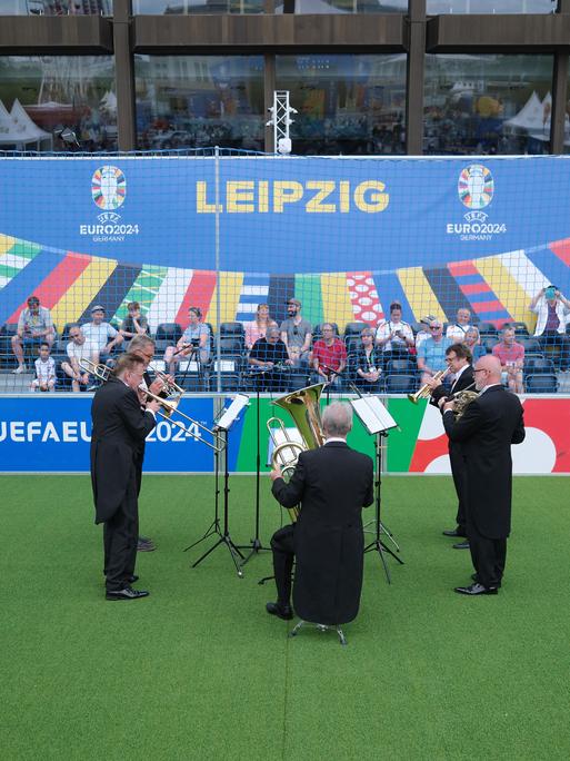 Musiker der Leipziger Blechbläsersolisten spielen auf einem Kunstrasenfeld auf dem Augustusplatz während der UEFA EURO 2024