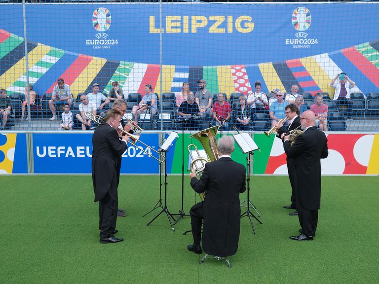 Musiker der Leipziger Blechbläsersolisten spielen auf einem Kunstrasenfeld auf dem Augustusplatz während der UEFA EURO 2024