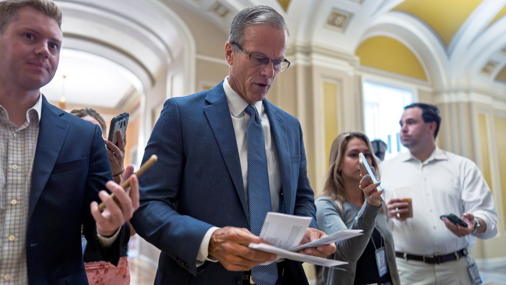 Der Mehrheitsführer im US-Senat, John Thune. Der Republikaner ist von mehreren Personen umringt. Der Mehrheitsführer im US-Senat, John Thune. Der Republikaner ist von mehreren Personen umringt.