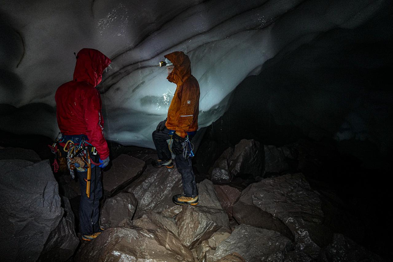 Zwei Menschen stehen in einer Eishöhle.