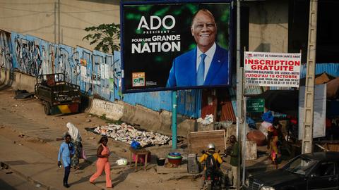 Menschen gehen an einer Wahlkampfanzeige des Präsidenten der Elfenbeinküste, Alassane Ouattara, vorbei. Die Elfenbeinküste wird am 25. Oktober 2025 Präsidentschaftswahlen abhalten. Menschen gehen an einer Wahlkampfanzeige des Präsidenten der Elfenbeinküste, Alassane Ouattara, vorbei. Die Elfenbeinküste wird am 25. Oktober 2025 Präsidentschaftswahlen abhalten.