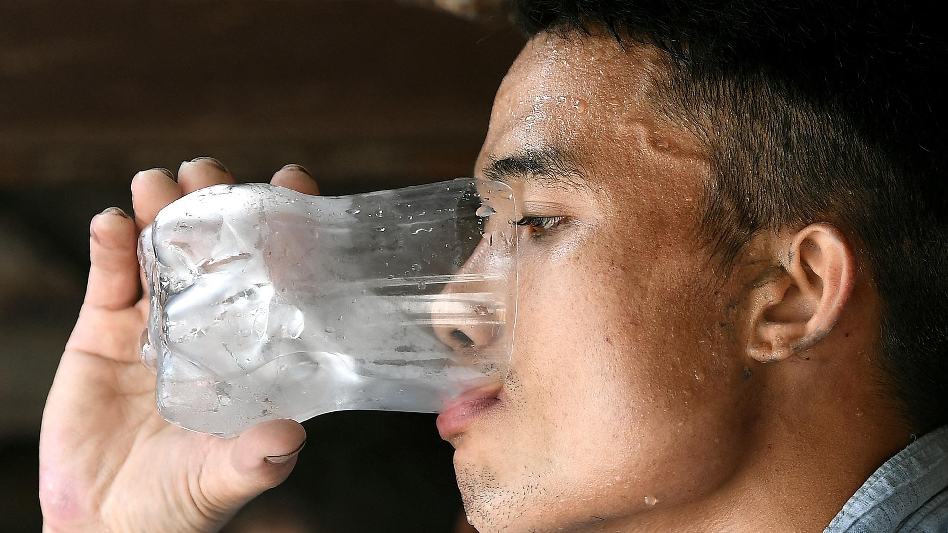 Ein Mann trinkt ein Glas Wasser.