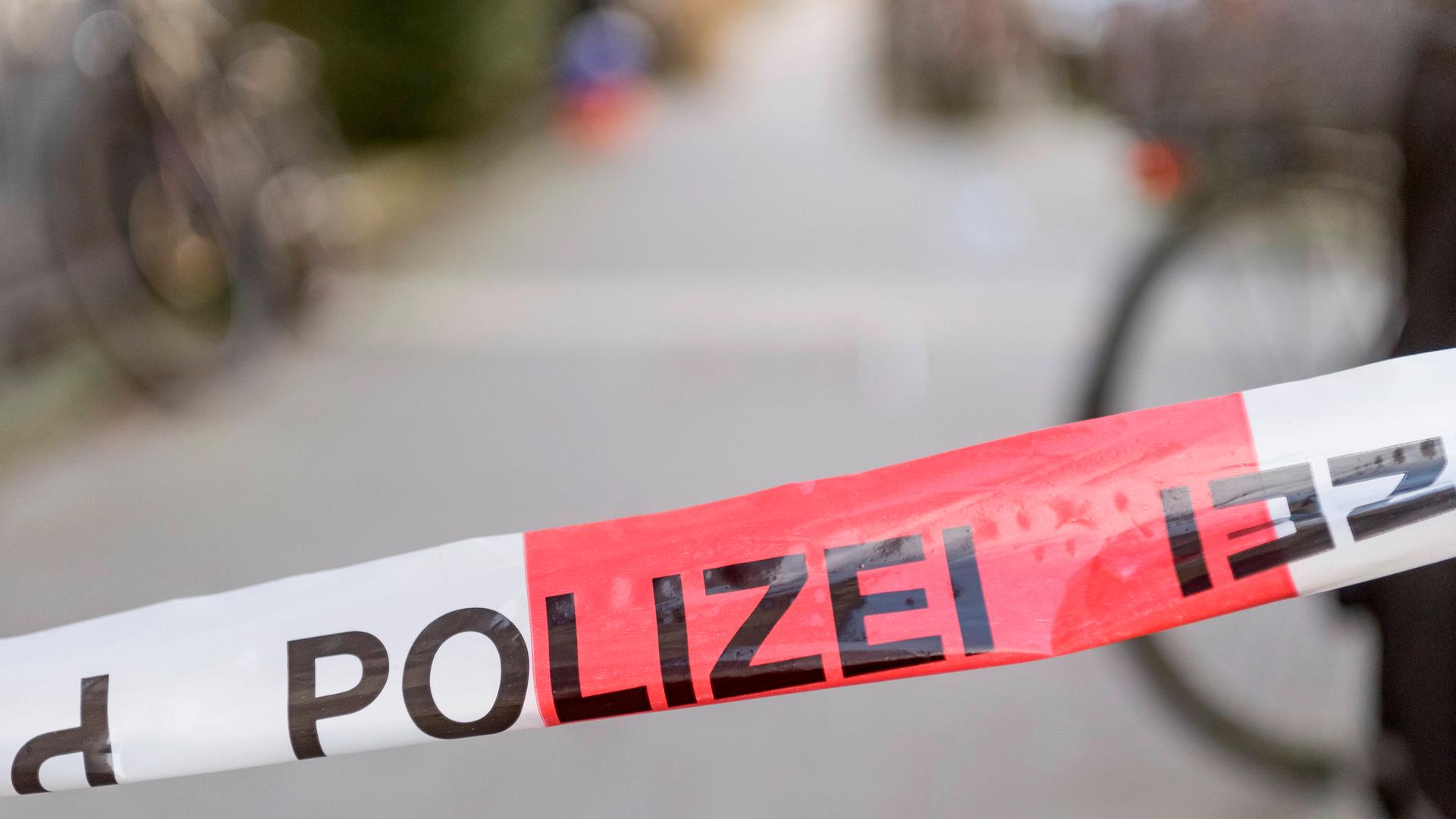 Ein rot-weißes Absperrband der Polizei riegelt einen Tatort ab.