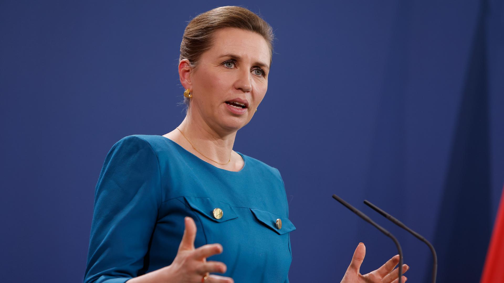Die dänische Premierministerin Mette Frederiksen gestikuliert vor einer blauen Wand. Die dänische Premierministerin Mette Frederiksen gestikuliert vor einer blauen Wand.