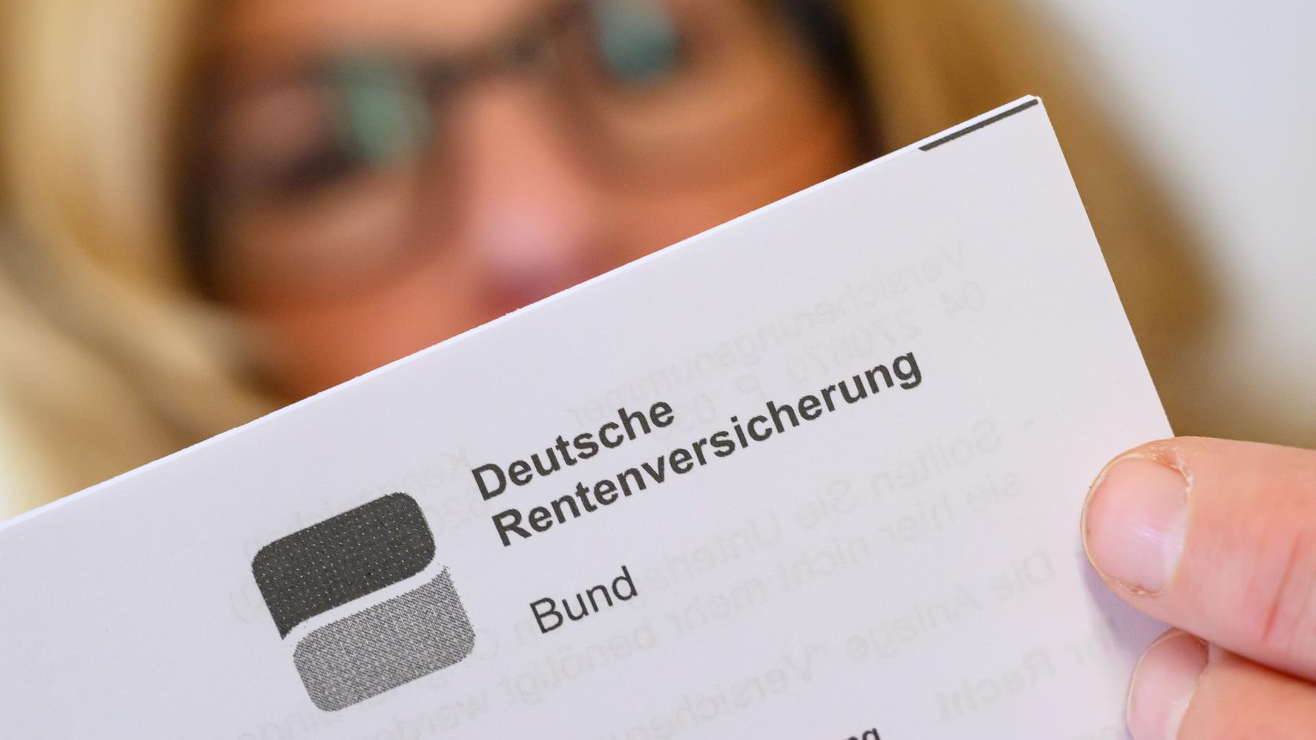 Eine Frau liest ein Schreiben der Deutschen Rentenversicherung. Man sieht den Brief im Vordergrund scharf und einen Teil des Kopfes der Frau mit Brille dahinter unscharf.