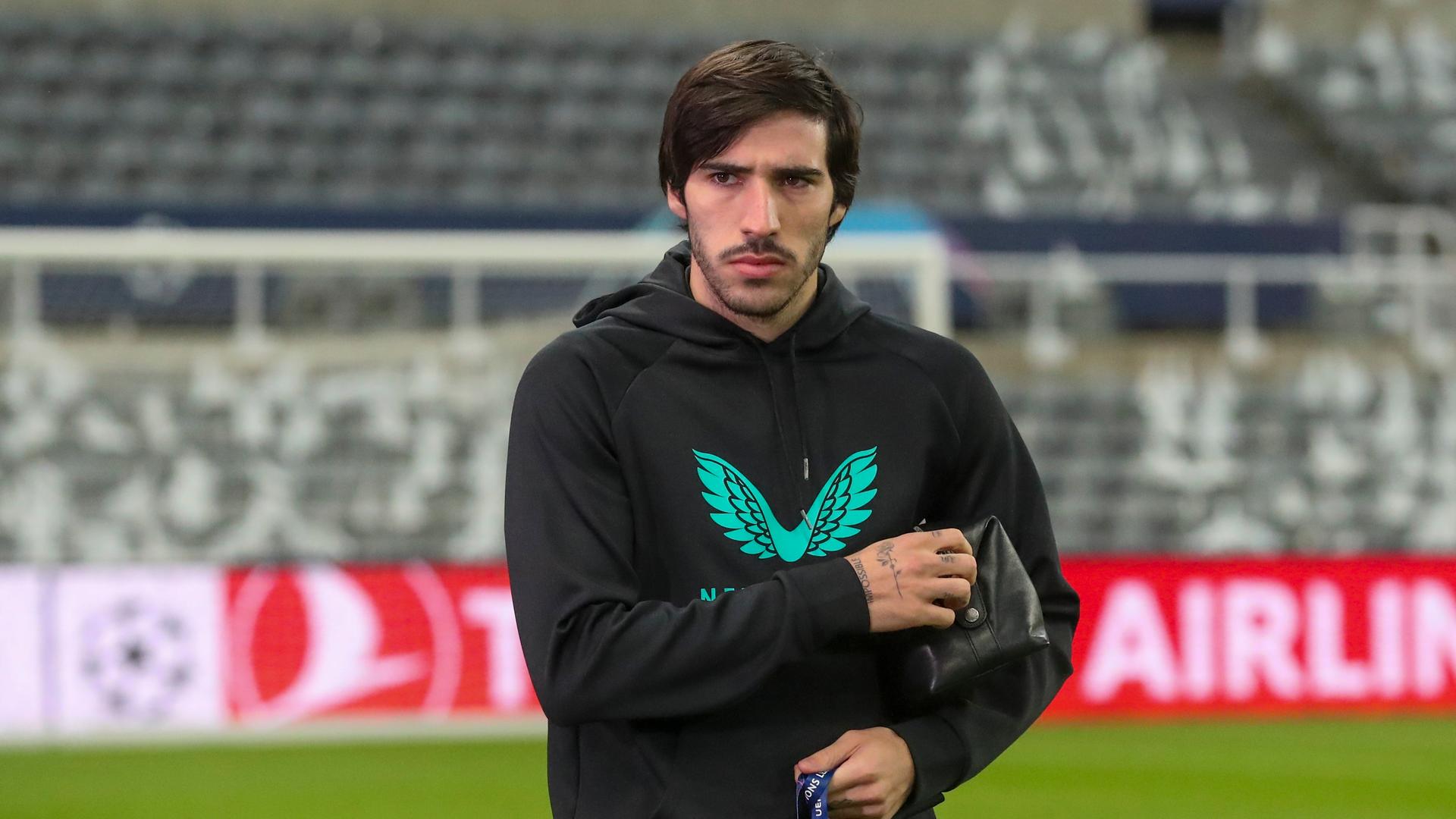 Sandro Tonali am Rand eines Fußballfeldes. Er blickt ernst.