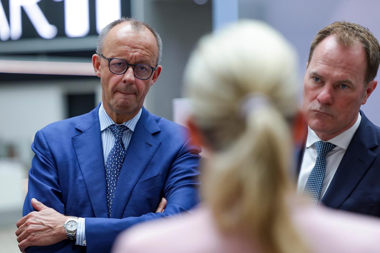 Kanzler und CDU-Chef Friedrich Merz (links) mit Düsseldorfs Oberbürgermeister Stefan Keller (CDU) in der Firma Henkel. Vor ihnen steht von hinten zu sehen eine blonde Frau