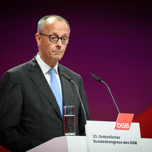 Bundeskanzler Friedrich Merz steht an einem Rednerpult mit dem Logo des Deutschen Gewerkschaftsbundes darauf. 