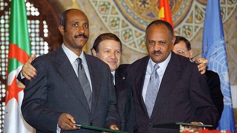 Der OAU-Vorsitzende und algerische Staatspräsident Abdelaziz Bouteflika (hinten in der Mitte) umarmt den äthiopischen Außenminister Seyoum Mesfin (links) und seinen eritreischen Amtskollegen Haile Weldet Ensae (rechts)