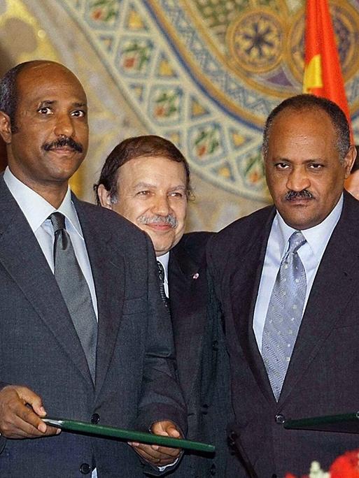 Der OAU-Vorsitzende und algerische Staatspräsident Abdelaziz Bouteflika (hinten in der Mitte) umarmt den äthiopischen Außenminister Seyoum Mesfin (links) und seinen eritreischen Amtskollegen Haile Weldet Ensae (rechts)