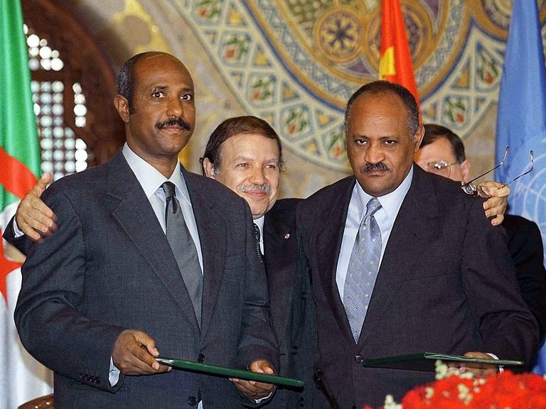 Der OAU-Vorsitzende und algerische Staatspräsident Abdelaziz Bouteflika (hinten in der Mitte) umarmt den äthiopischen Außenminister Seyoum Mesfin (links) und seinen eritreischen Amtskollegen Haile Weldet Ensae (rechts)