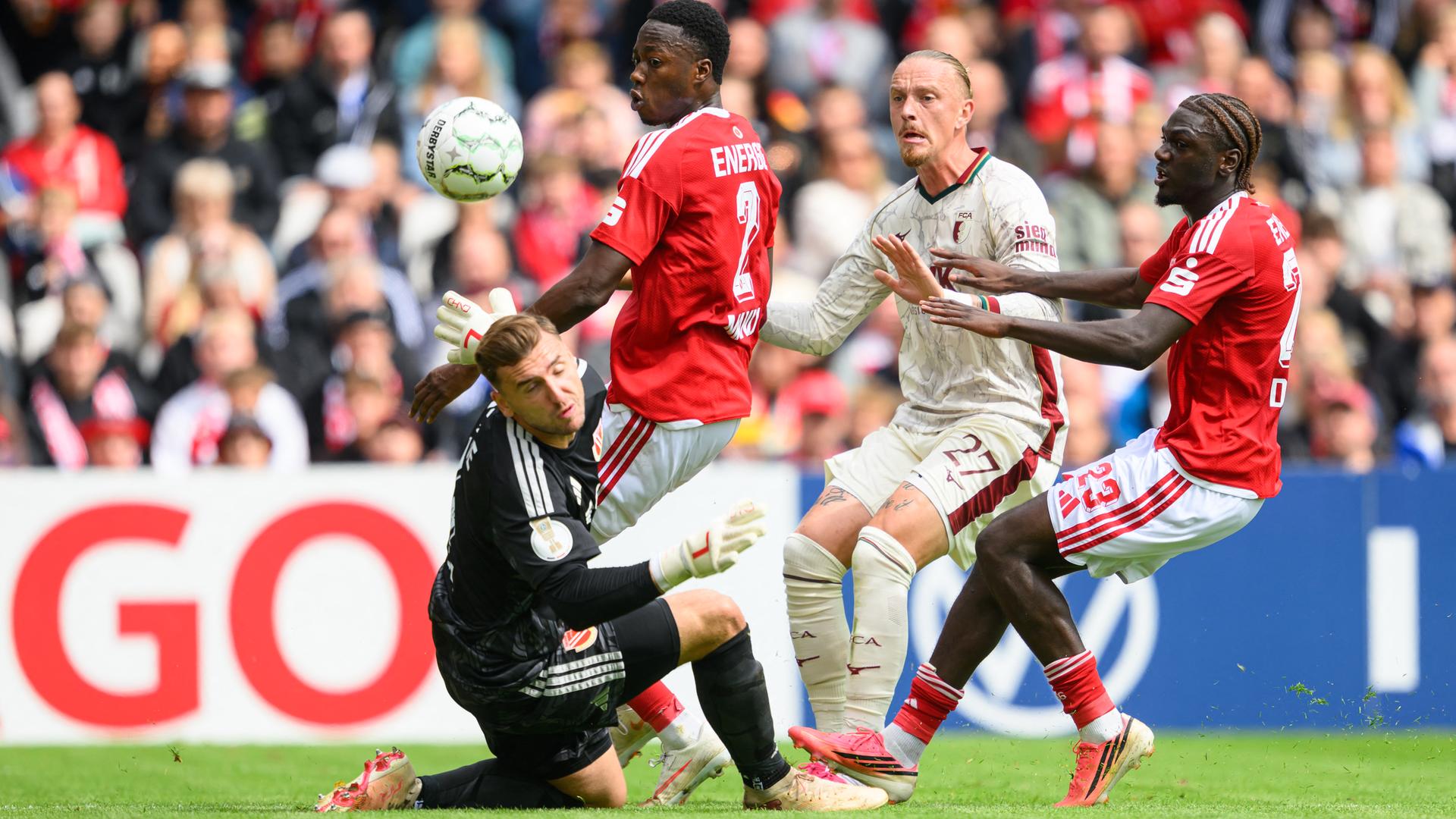 Mehrere Fußballspieler kämpfen um den Ball. 