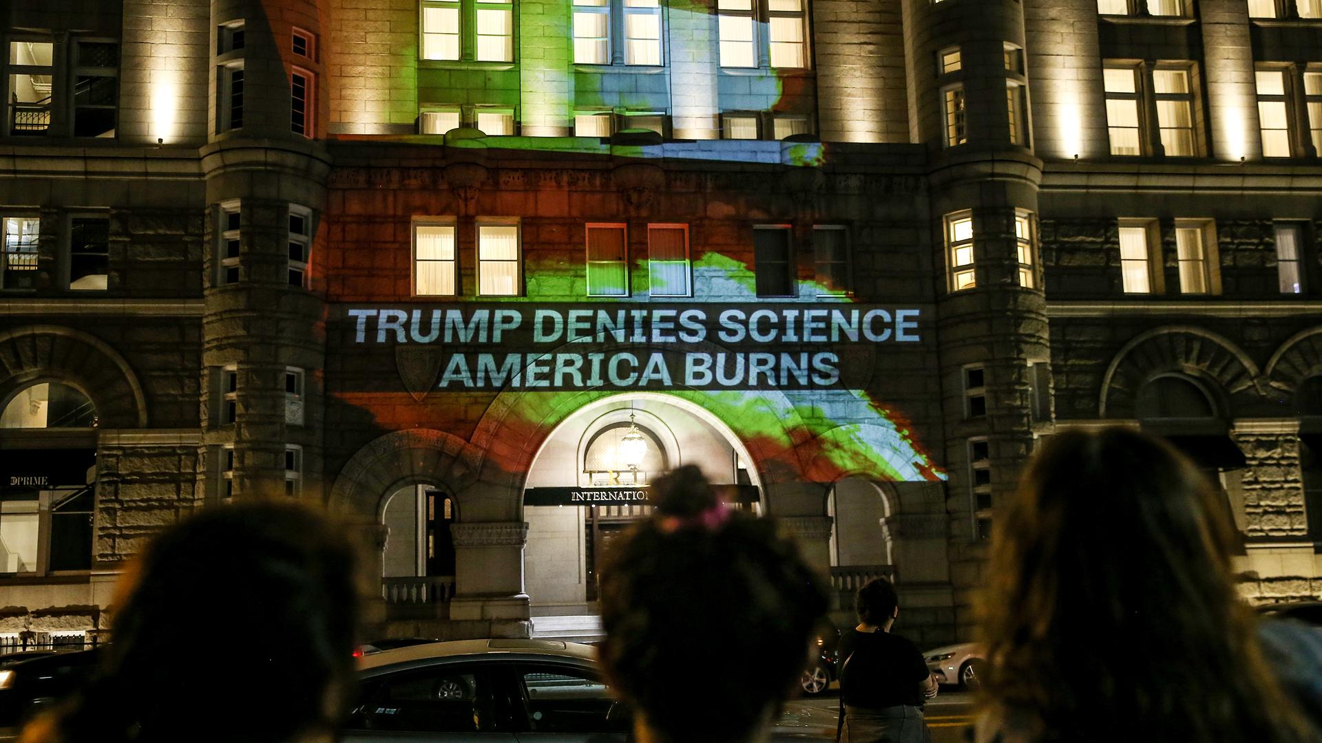 Aktivisten projizieren Flammen und den Spruch "Trump denies science - America burns" (Trump verleugnet Wissenschaft - Amerika brennt) auf eine Wand des Trump International Hotel in Washington.