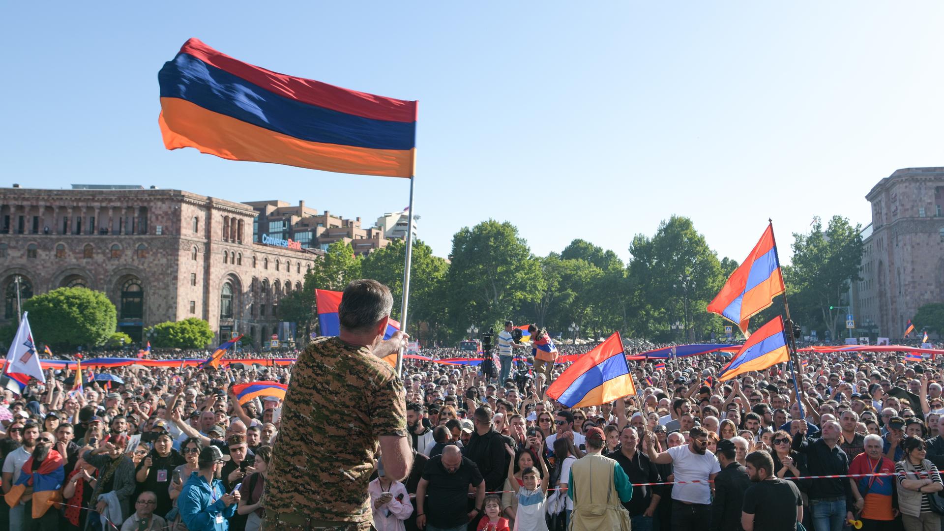 Eine Menschenmenge in Eriwan, der Hauptstadt von Armenien, demonstriert gegen Regierungschef Paschinjan. Teilnehmer schwenken armenische Flaggen. 