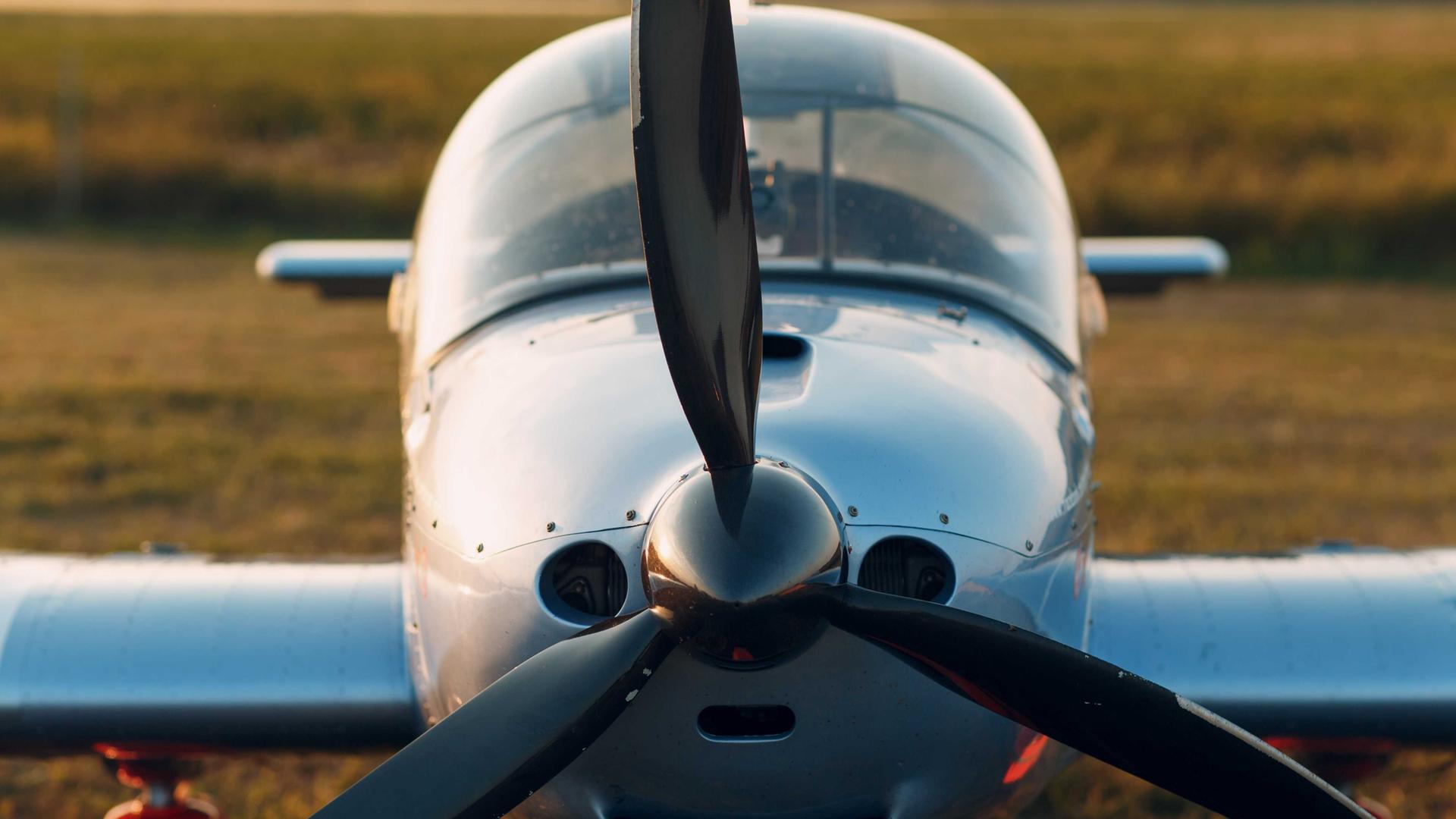 Frontansicht eines alten Propeller-Flugzeugs auf dem Feld