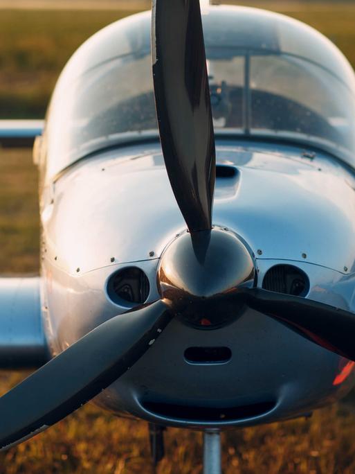 Frontansicht eines alten Propeller-Flugzeugs auf dem Feld