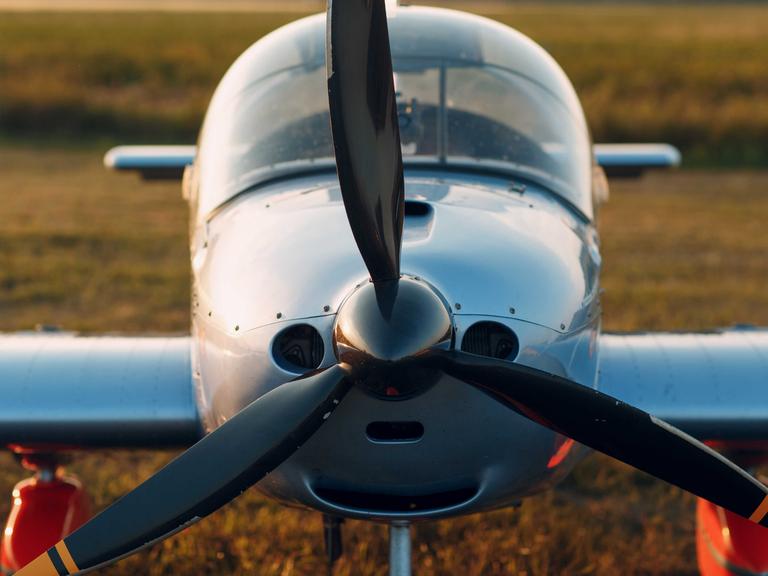 Frontansicht eines alten Propeller-Flugzeugs auf dem Feld