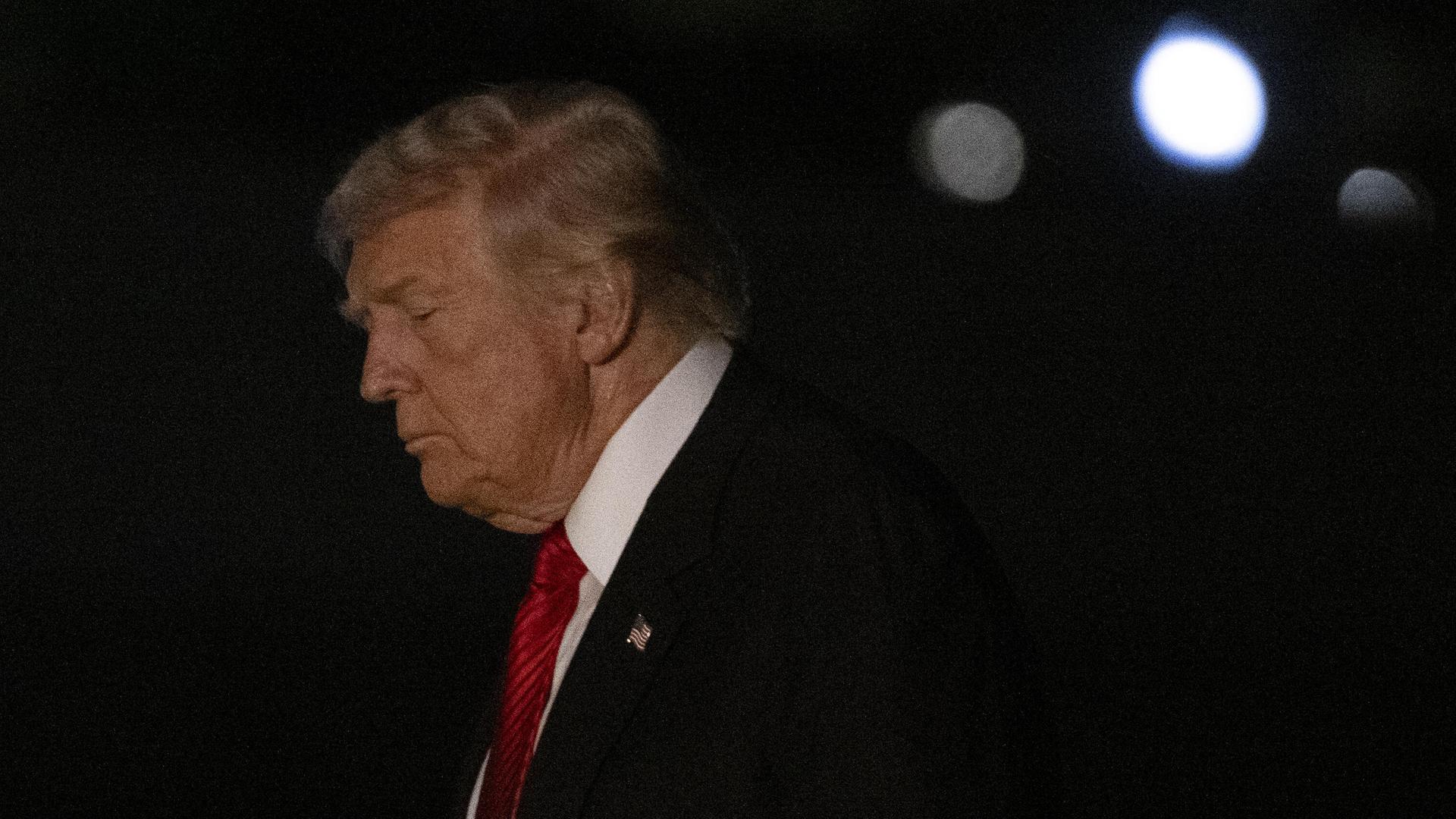 US-Präsident Trump im Anzug mit roter Krawatte in der Dunkelheit US-Präsident Trump im Anzug mit roter Krawatte in der Dunkelheit