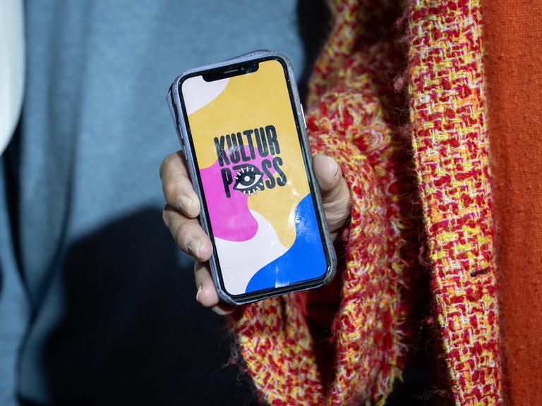 Auf einem in die Kamera gehaltenen Smartphone ist die Kulturpass-App zu sehen.