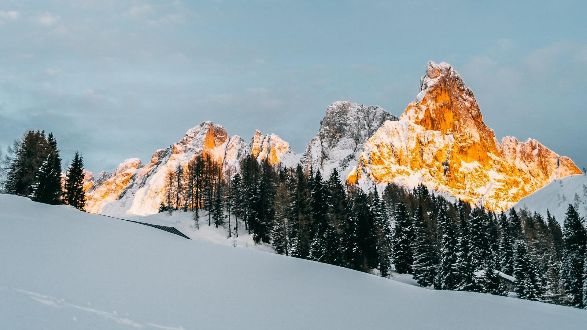 Blick auf Sonnen beschienene Berge im Schnee.