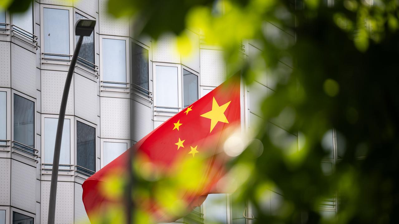 Ein chinesische Flagge weht vor einem Gebäude. 