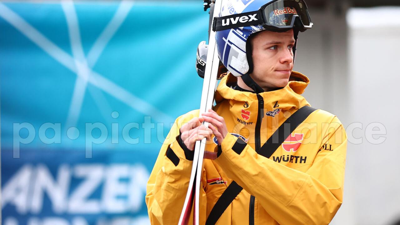 Andreas Wellinger trägt seine Skier auf dem Rücken, schaut enttäuscht zur Seite. Andreas Wellinger trägt seine Skier auf dem Rücken, schaut enttäuscht zur Seite.