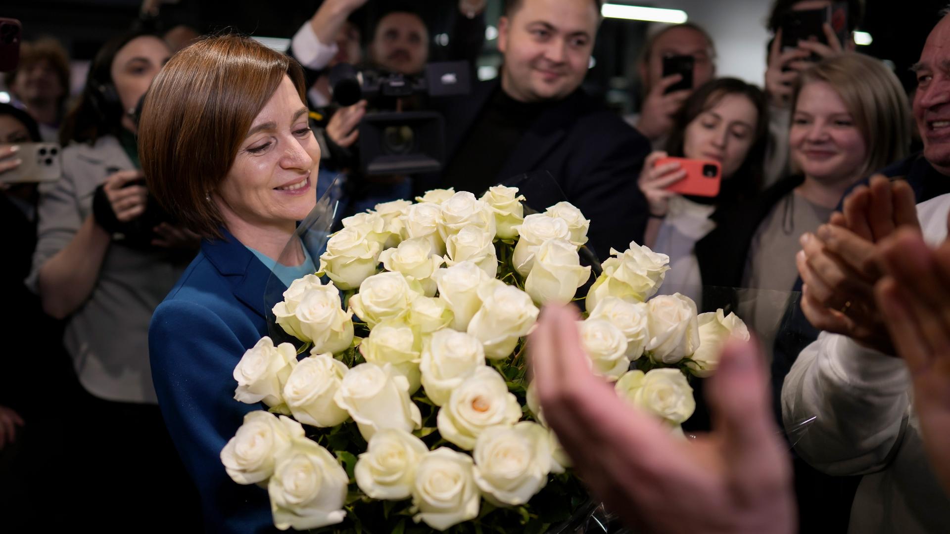 Moldau, Chisinau: Maia Sandu, amtierende Präsidentin von Moldau und Präsidentschaftskandidatin der PAS, lächelt und hält einen Blumenstrauß in der Hand.