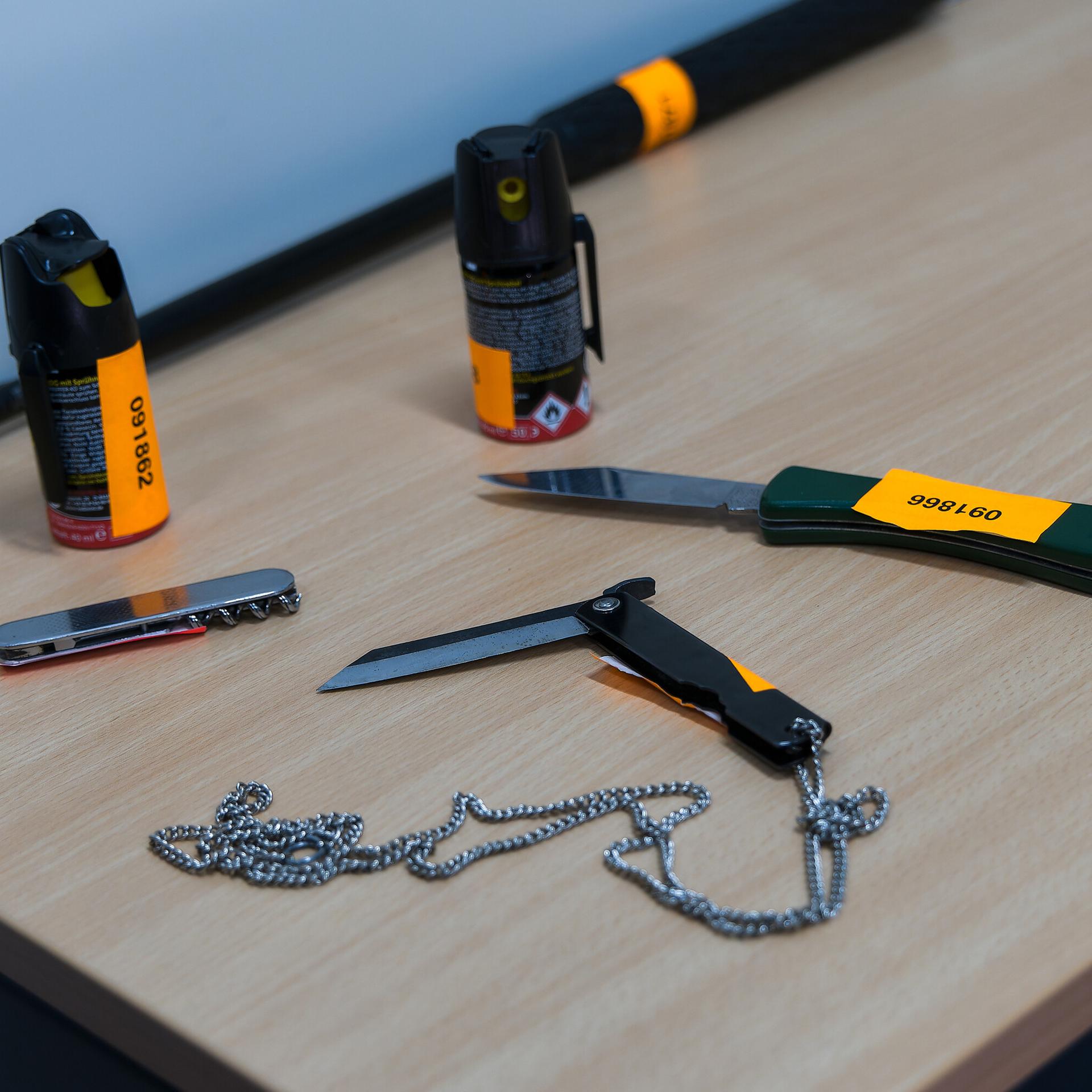 Die Bundespolizei präsentiert Gegenstände, darunter Pfefferspray, Messer und ein Teleskopschlagstock, die bei Kontrollen am Hauptbahnhof in Hamburg sichergestellt worden sind.