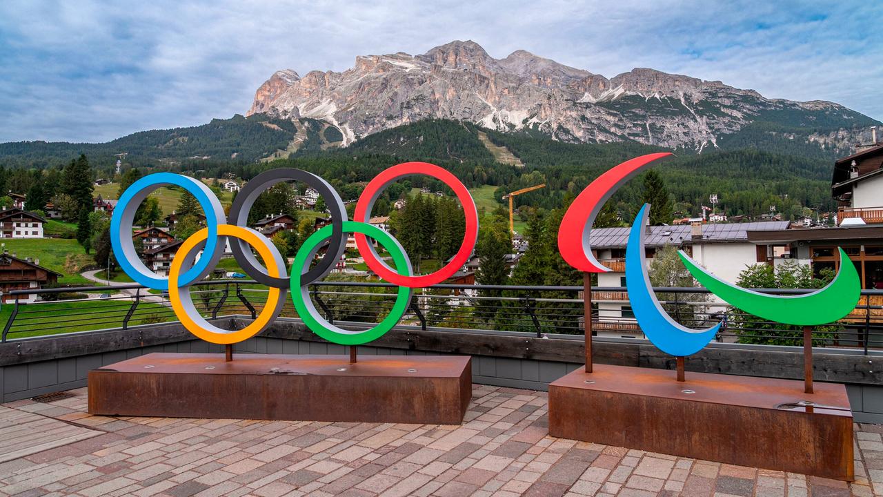 Olympische Ringe vor einem Bergpanaorama.