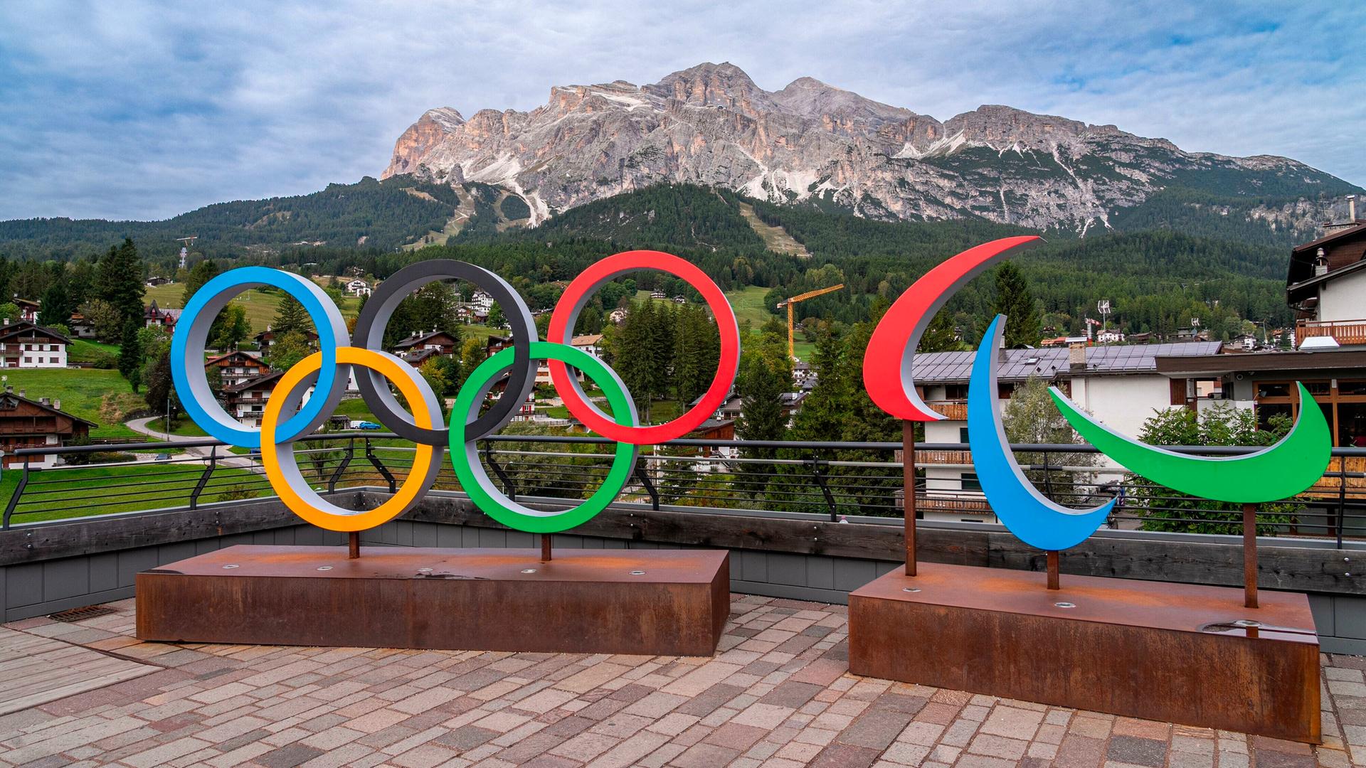 Olympische Ringe vor einem Bergpanorama.