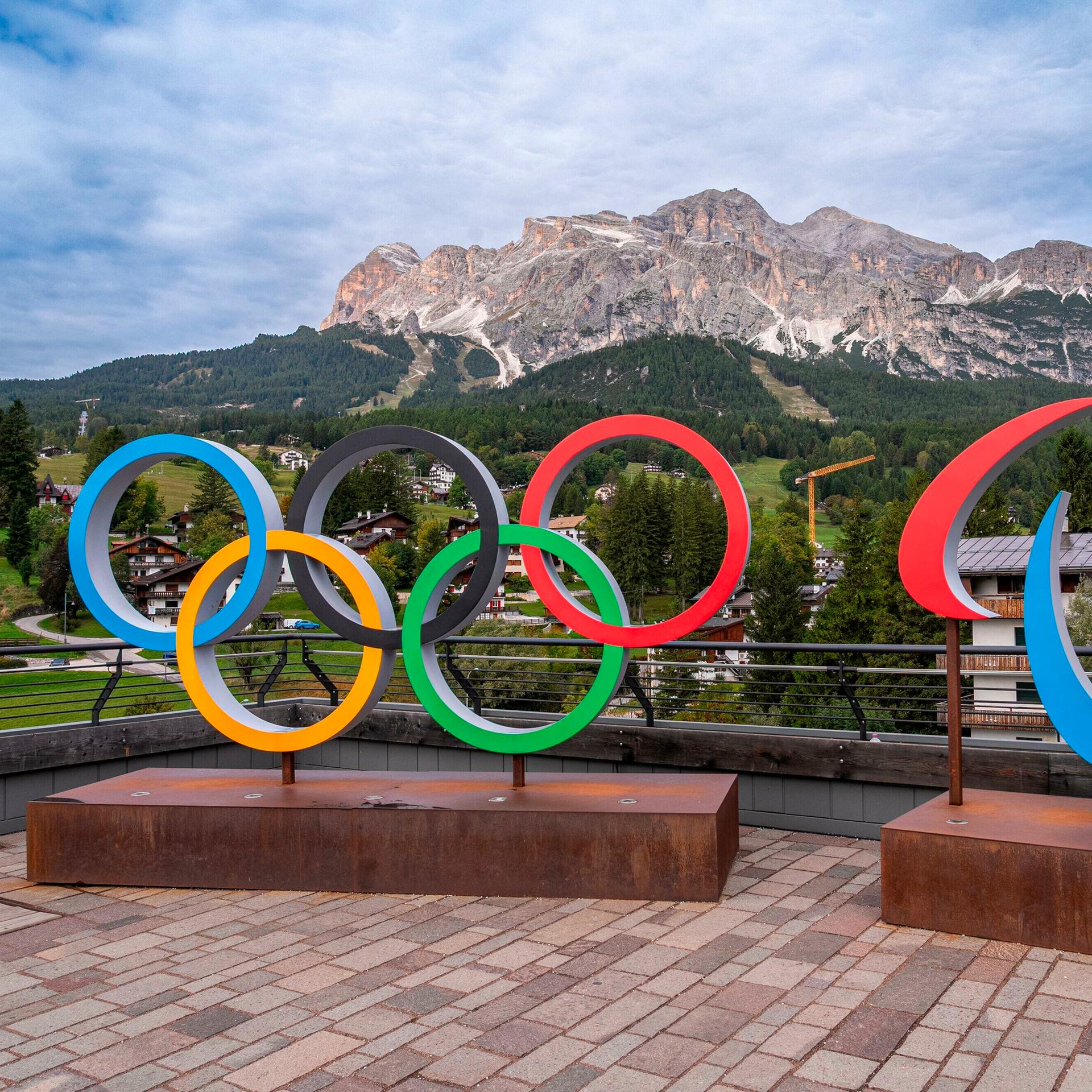 Olympische Ringe vor einem Bergpanaorama.