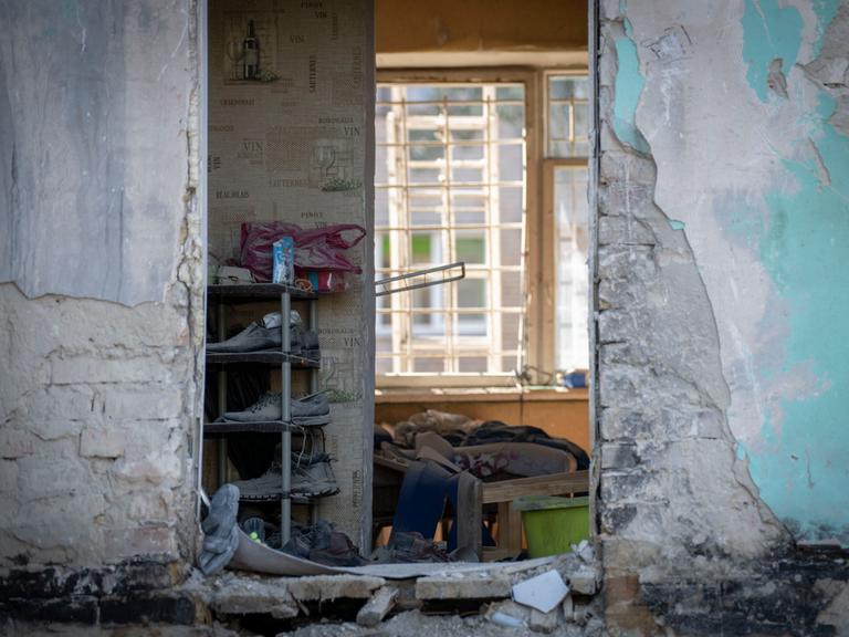 Massive Schäden durch Bombeneinschläge an einem Wohnhaus in Kiew. Die Fassade ist weggerissen und man blickt direkt in eine Wohunung.