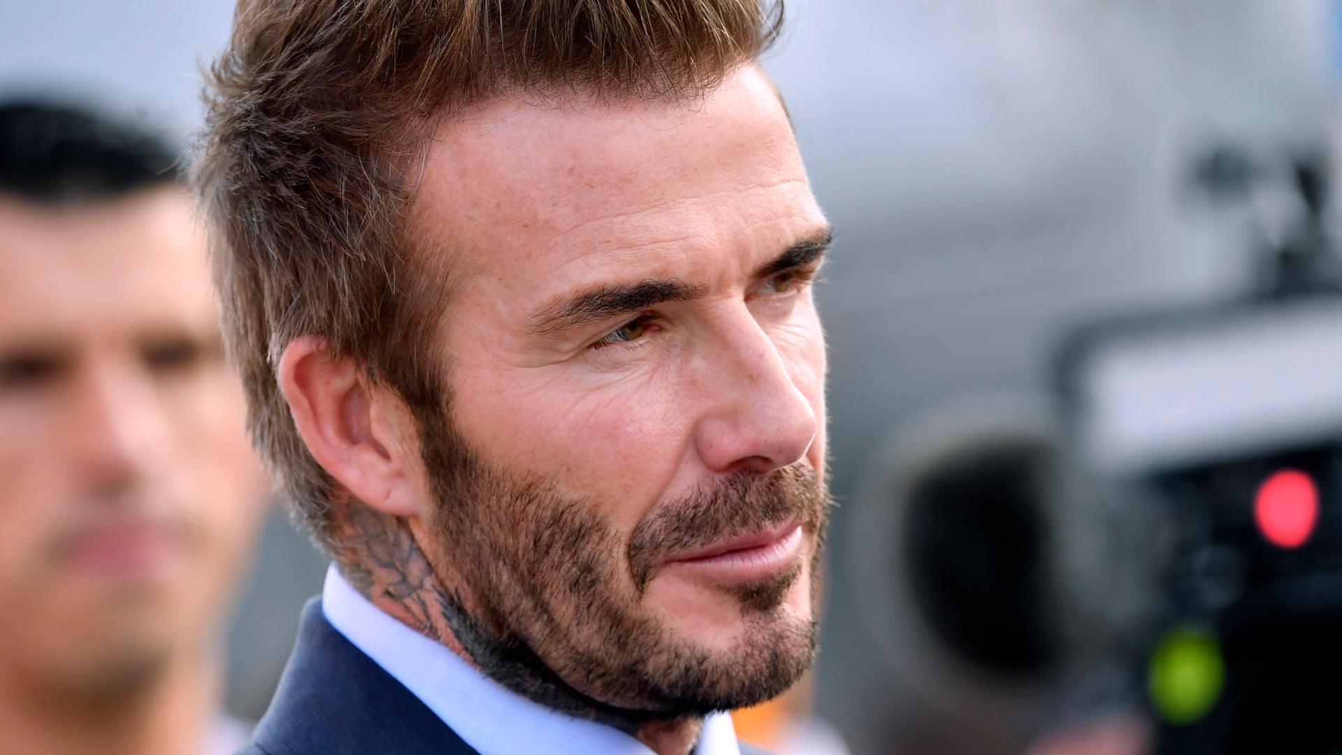 David Beckham im Anzug schaut in eine Kamera.