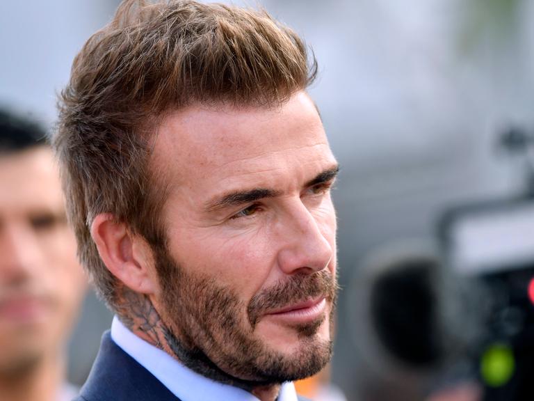 David Beckham im Anzug schaut in eine Kamera.