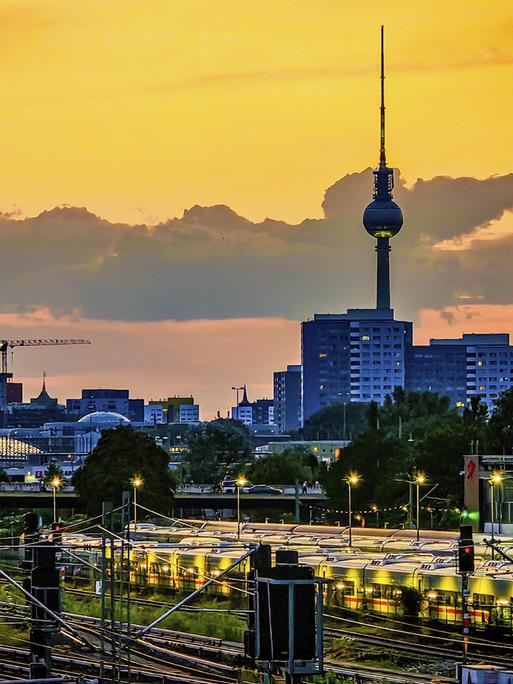 Blick über die Skyline von Berlin am Abend: Hinter Bahngleisen und geparkten Zügen sind die Gebäude der Stadt und der Fernsehturm zu sehen. Blick über die Skyline von Berlin am Abend: Hinter Bahngleisen und geparkten Zügen sind die Gebäude der Stadt und der Fernsehturm zu sehen.