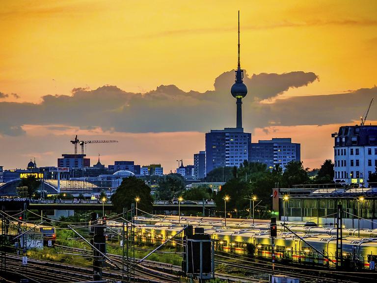 Blick über die Skyline von Berlin am Abend: Hinter Bahngleisen und geparkten Zügen sind die Gebäude der Stadt und der Fernsehturm zu sehen. Blick über die Skyline von Berlin am Abend: Hinter Bahngleisen und geparkten Zügen sind die Gebäude der Stadt und der Fernsehturm zu sehen.