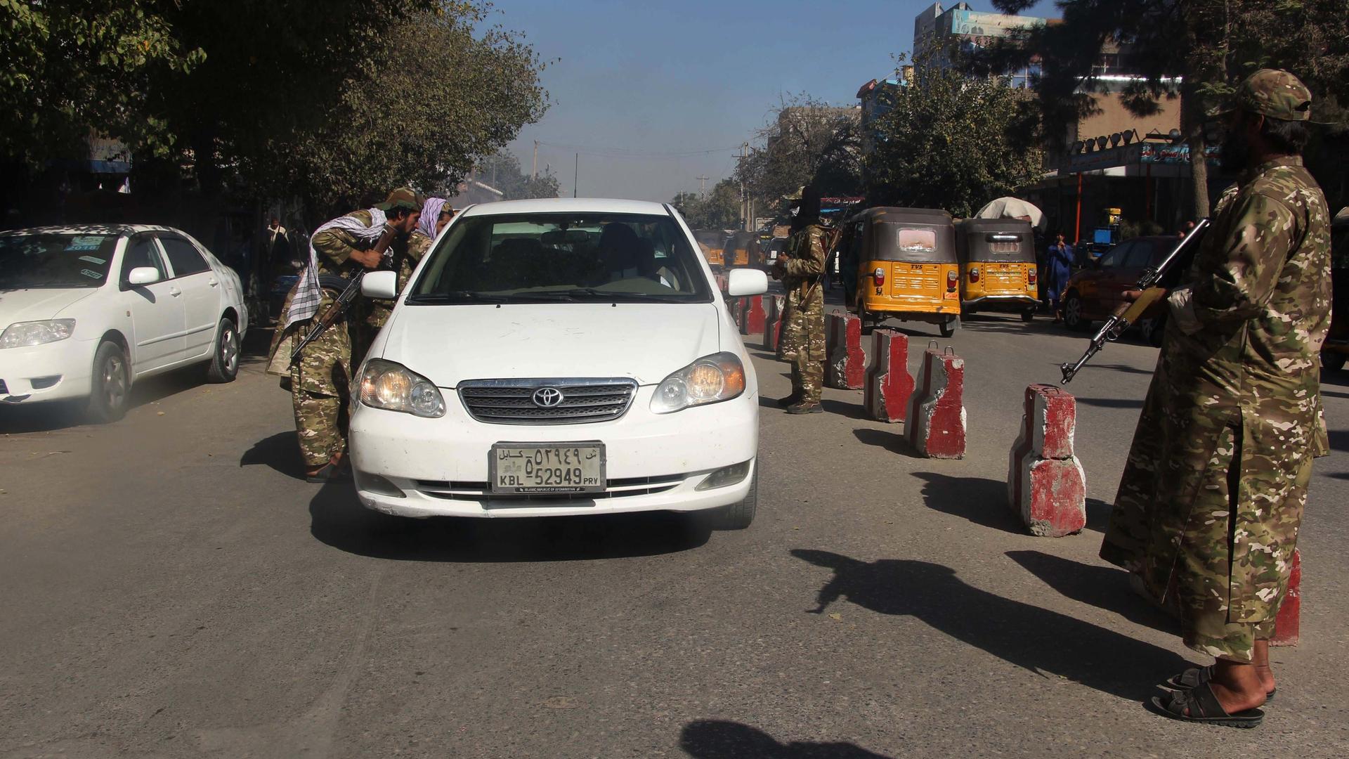 Taliban überprüfen an einem Checkpoint im afghanischen Kundus ein Auto im September 2021. 