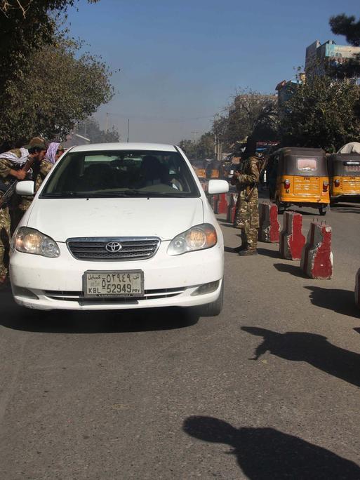 Taliban überprüfen an einem Checkpoint im afghanischen Kundus ein Auto im September 2021. 