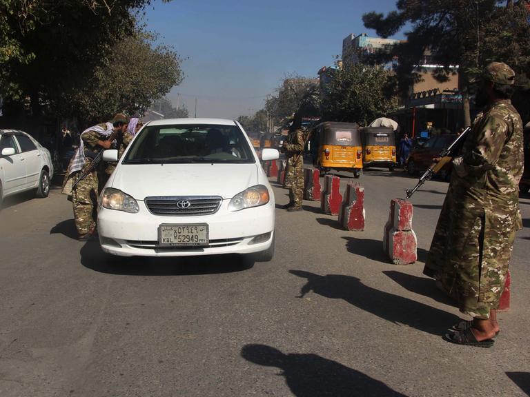 Taliban überprüfen an einem Checkpoint im afghanischen Kundus ein Auto im September 2021. 