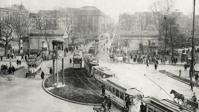 Schwarzweißfotografie vom belebten Straßen- und Fußgängerverkehr auf dem Potsdamer Platz in den 1920er-Jahren.