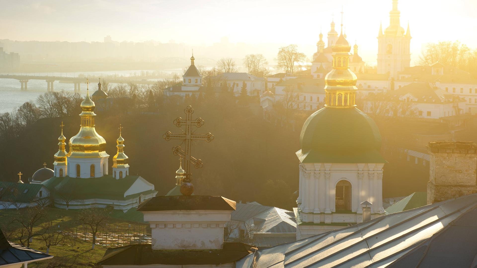 Teile der Klosteranlage Kiewer Höhlenkloster vor dem Fluss Dnepr in der Abendsonne. Teile der Klosteranlage Kiewer Höhlenkloster vor dem Fluss Dnepr in der Abendsonne.