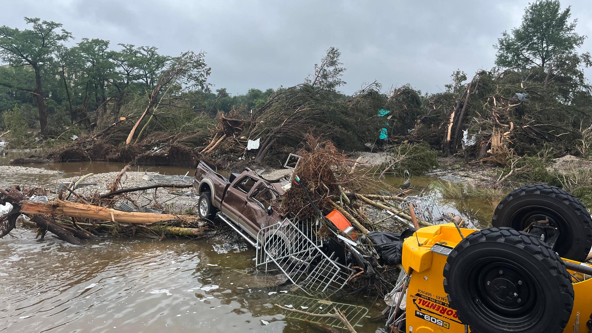Das Bild zeigt ein zerstörtes Auto. Die Flut hat das Auto mitgerissen. Das Auto liegt zusammen mit anderen zerstörten Dingen im Wasser. Das Bild zeigt ein zerstörtes Auto. Die Flut hat das Auto mitgerissen. Das Auto liegt zusammen mit anderen zerstörten Dingen im Wasser.