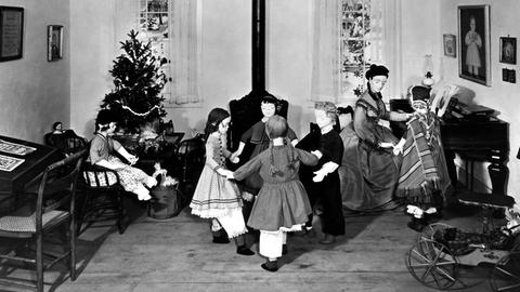 Diorama des ersten amerikanischen Kindergartens, der 1856 von Margarethe Meyer-Schurz in Watertown, Wisconsin in den USA eröffnet wurde. Kinderpuppen tanzen im Kreis vor einem Ofen, im Hintergrund steht ein geschmückter Weihnachtsbaum.
