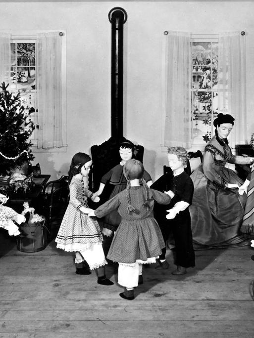 Diorama des ersten amerikanischen Kindergartens, der 1856 von Margarethe Meyer-Schurz in Watertown, Wisconsin in den USA eröffnet wurde. Kinderpuppen tanzen im Kreis vor einem Ofen, im Hintergrund steht ein geschmückter Weihnachtsbaum.