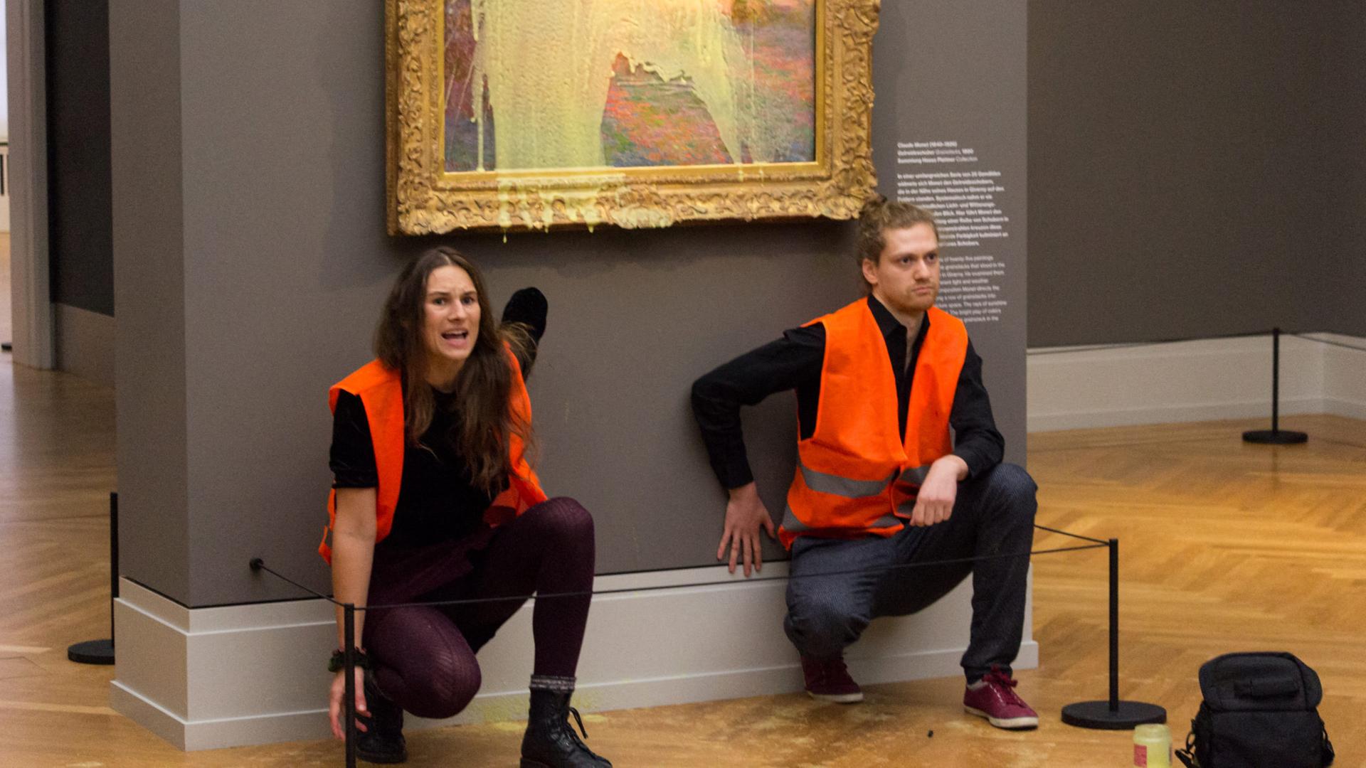 Klimaaktivisten der Gruppe "Letzte Generation" haben sich unter dem Monet-Gemälde, das sie mit Kartoffelbrei beworfen haben, festgeklebt