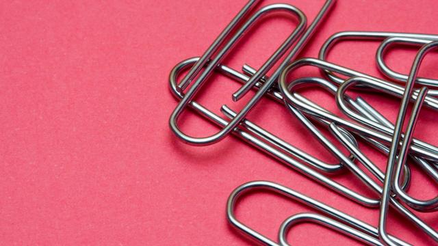 Nahaufnahme von Büroklammern auf rosafarbenem Untergrund