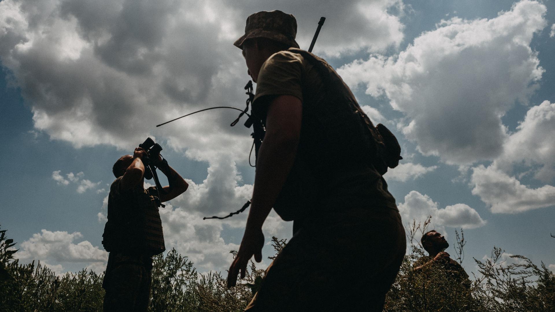 Soldaten der ukrainischen Armee halten mit Ferngläsern Ausschau nach russischen Drohnen.
