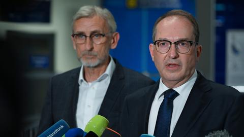 Alexander Dobrindt (CSU), Bundesinnenminister, spricht bei einer Pressekonferenz in einem Terminal des Flughafens Leipzig/Halle. Hinter ihm steht Armin Schuster (CDU), Innenminister von Sachsen. 