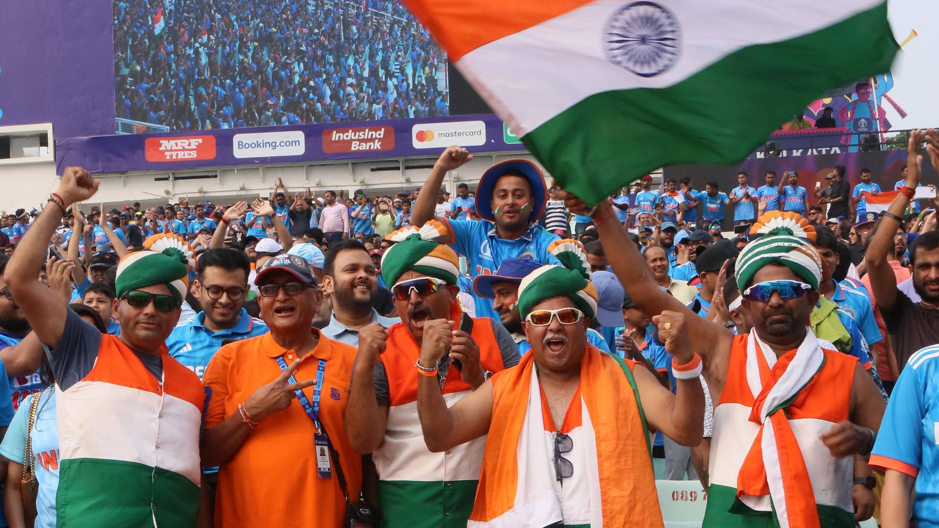 Blick auf indische Fans, sie jubeln und schwenken die indische Flagge.