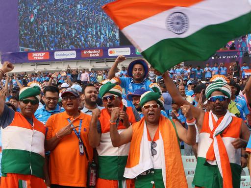 Blick auf indische Fans, sie jubeln und schwenken die indische Flagge.